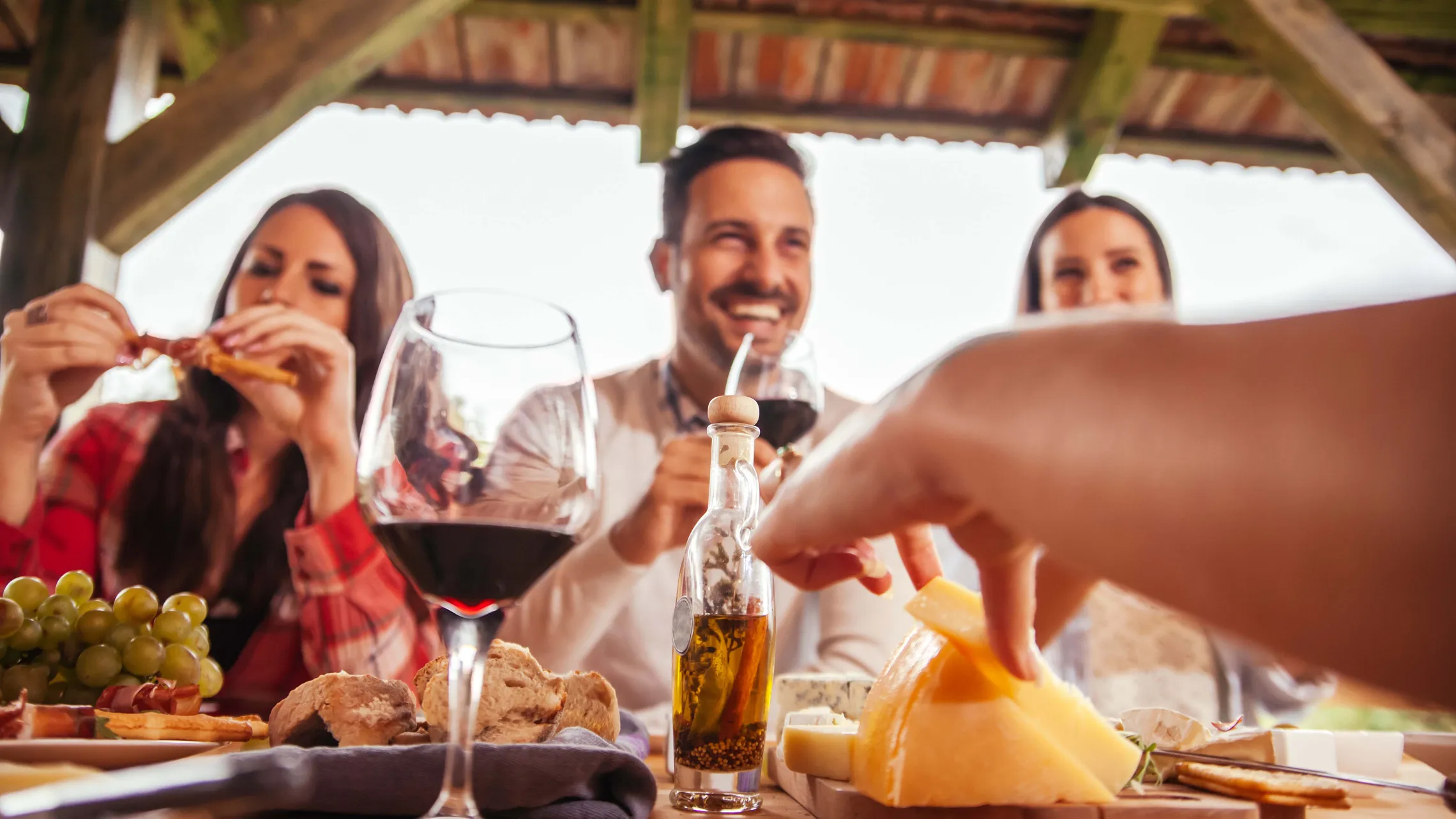Mehrere Personen beim Essen von einer Käsejause mit Weinbegleitung