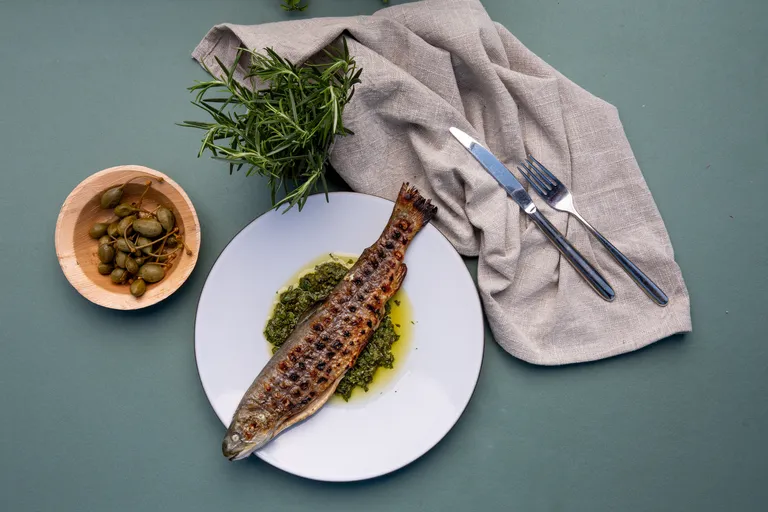 Gegrillter ganzer Fisch auf Kräutersauce mit Kapern und frischem Rosmarin