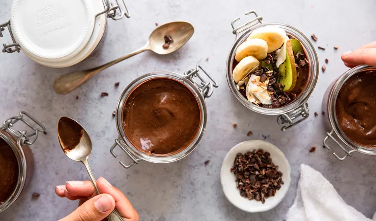 Cremiger Schokopudding im Glas mit Banane, Kiwi, Kokosflocken und Kakaonibs als Topping