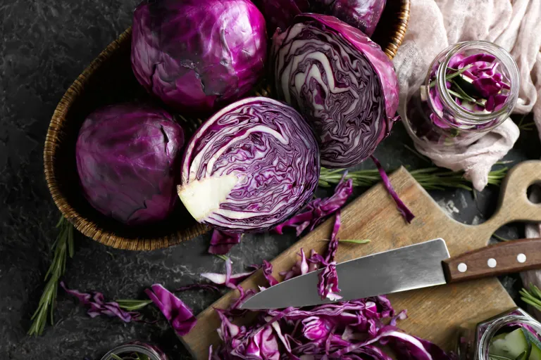 Halbierter Rotkohl mit Messer und geschnittenem Rotkraut auf Schneidebrett