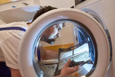 Person montiert eine Waschmaschine
