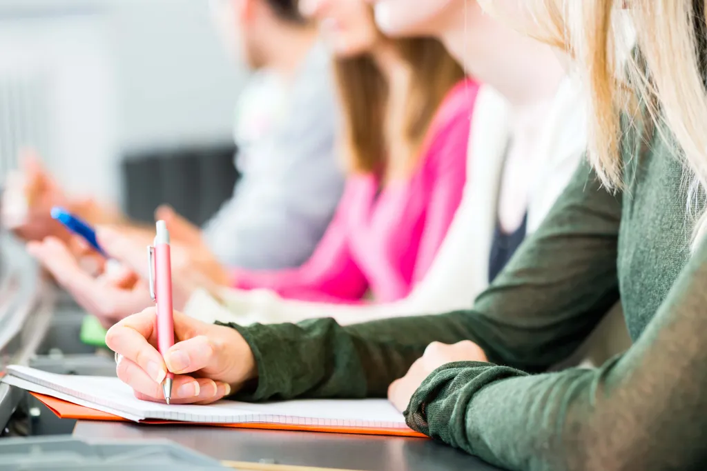 Teilnehmerinnen machen sich während eines Seminars oder einer Weiterbildung Notizen