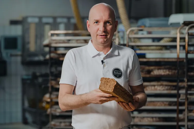 Bäckermeister Hans Jürgen Kölly der INTERSPAR-Bäckerei lächelt mit seinem Bäckerliebling in die Kamera