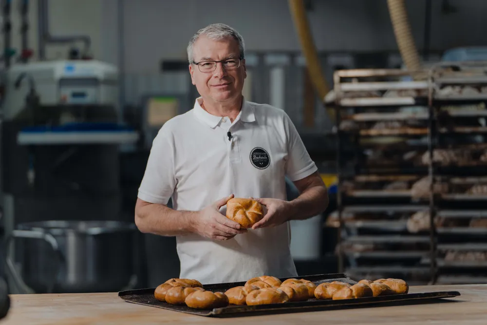 Bäckermeister Hermann Schöpf der INTERSPAR-Bäckerei lächelt mit seinem Bäckerliebling in die Kamera