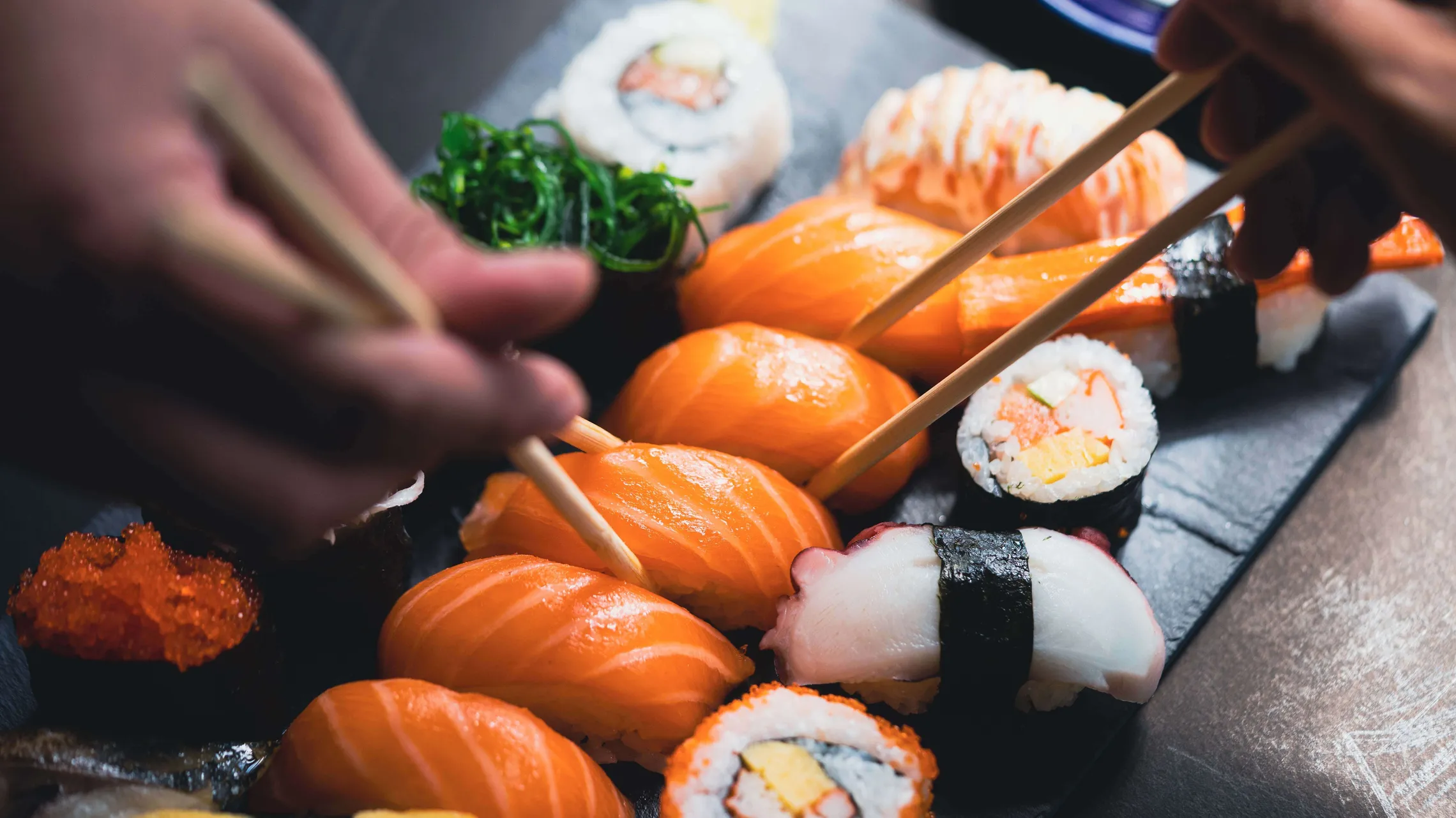 Auswahl an Sushi und Nigiri mit Lachs, Maki und Algensalat, serviert auf einer Platte