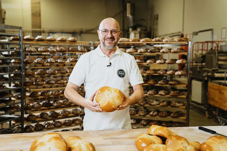 Bäckermeister Johann Pilz der INTERSPAR-Bäckerei lächelt mit seinem Bäckerliebling in die Kamera