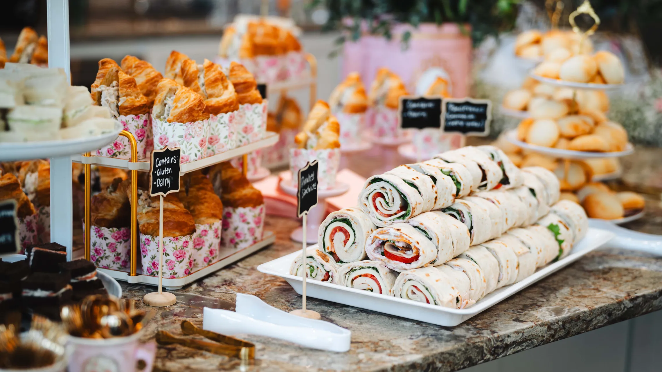 Ein Buffet-Tisch mit Muffins, Wraps und Fingerfood