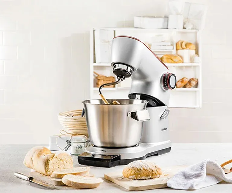 Bosch Küchenmaschine auf Küchenzeile, im Hintergrund Brot