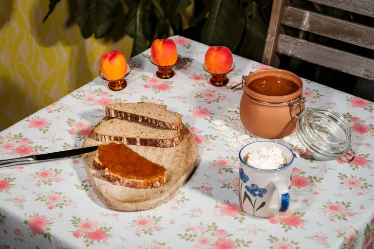 Brot mit Marillenmarmelade auf einem Frühstückstisch