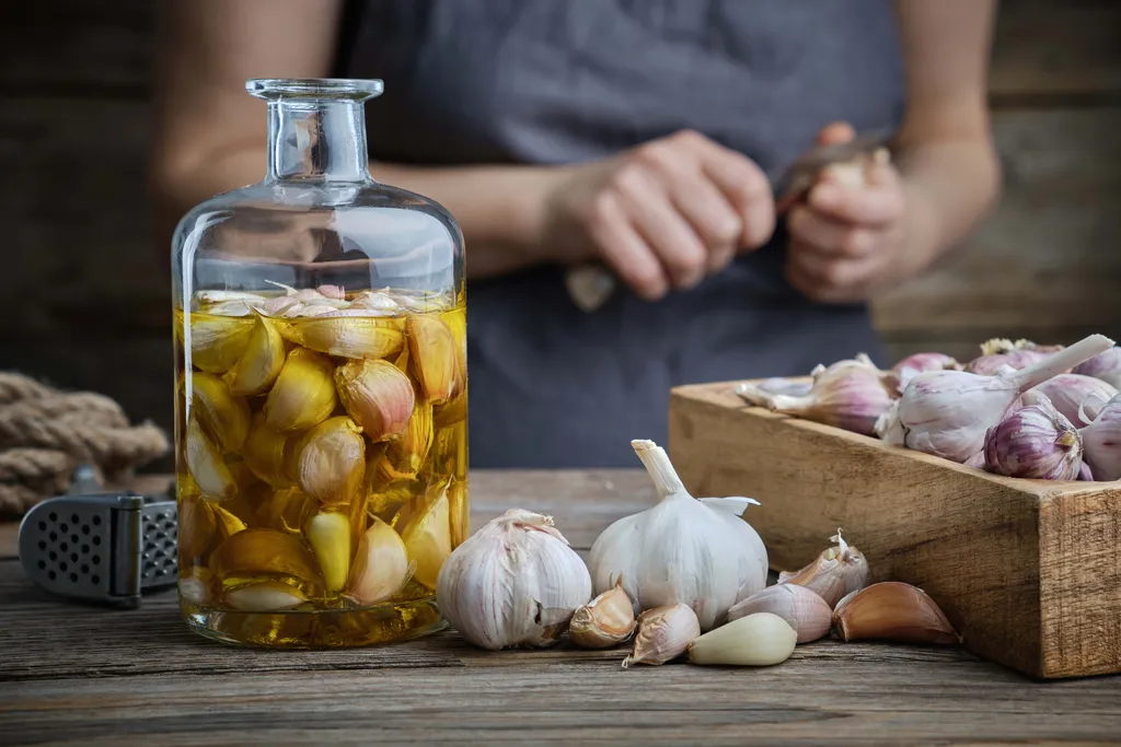 Knoblauchzehen werden in Öl eingelegt
