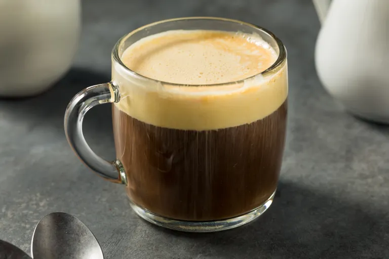 Eine durchsichtige Glastasse mit einem Ca Phe Trung (Vietnamesischer Kaffee mit Ei)