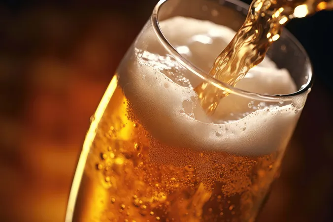 Frisch gezapftes Bier fließt in ein schräg gehaltenes Bierglas