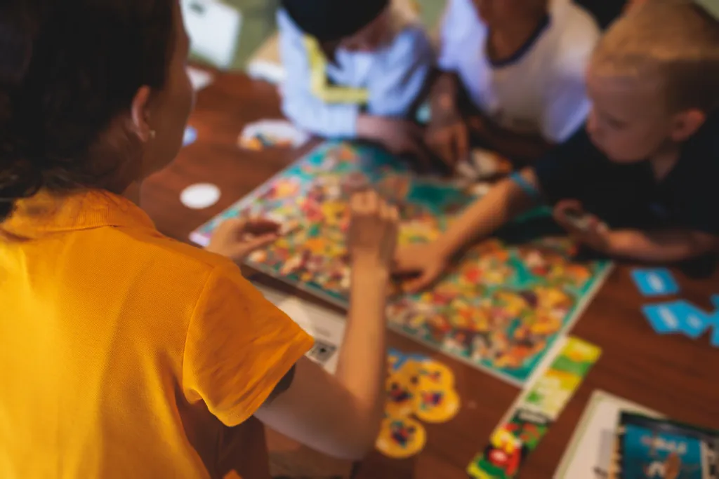 Kinder spielen ein Brettspiel auf einem niedrigen Couchtisch