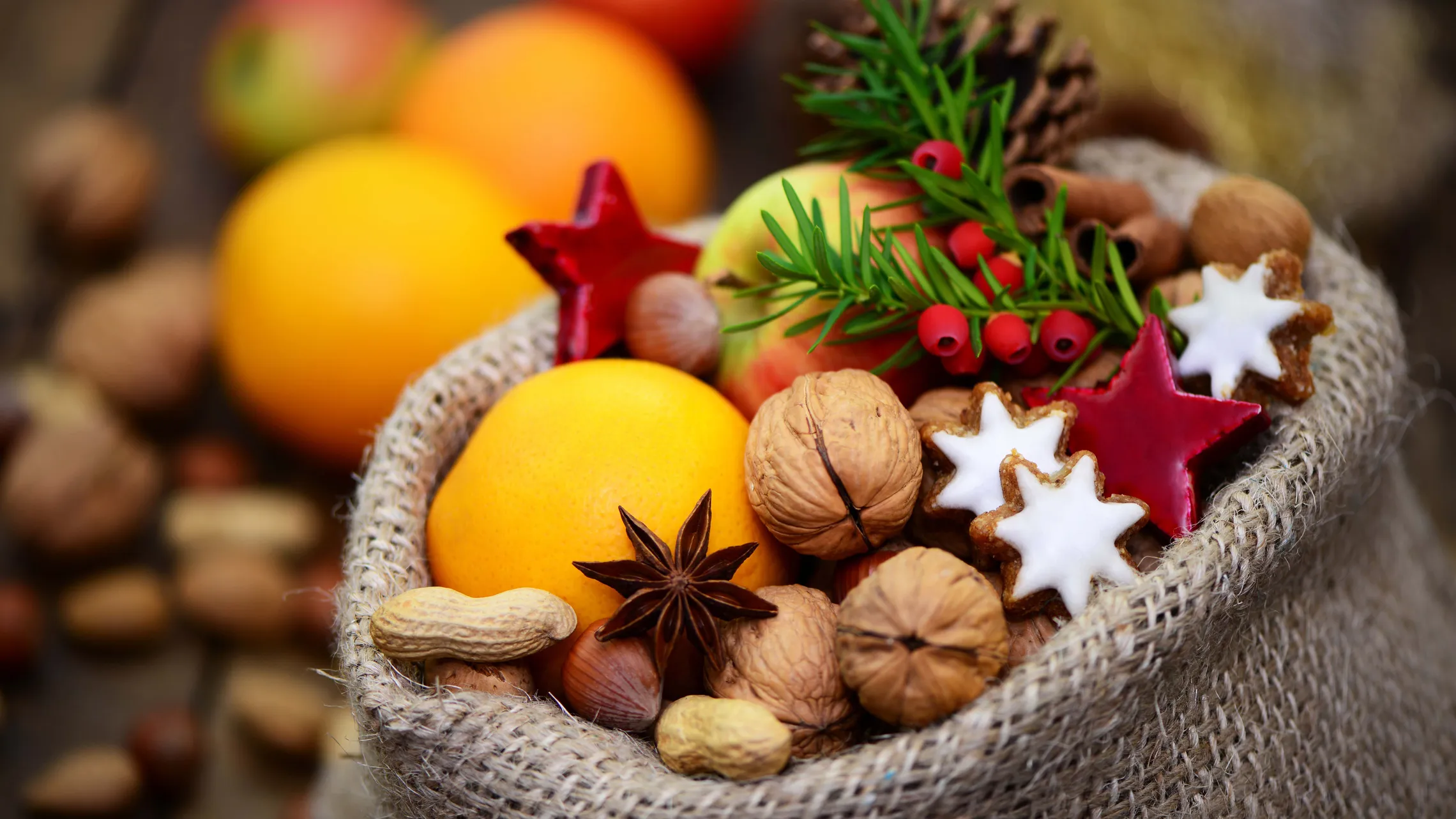 Weihnachtliche Mischung aus Nüssen, Orangen, Zimtsternen, Zimt und Tannenzweigen