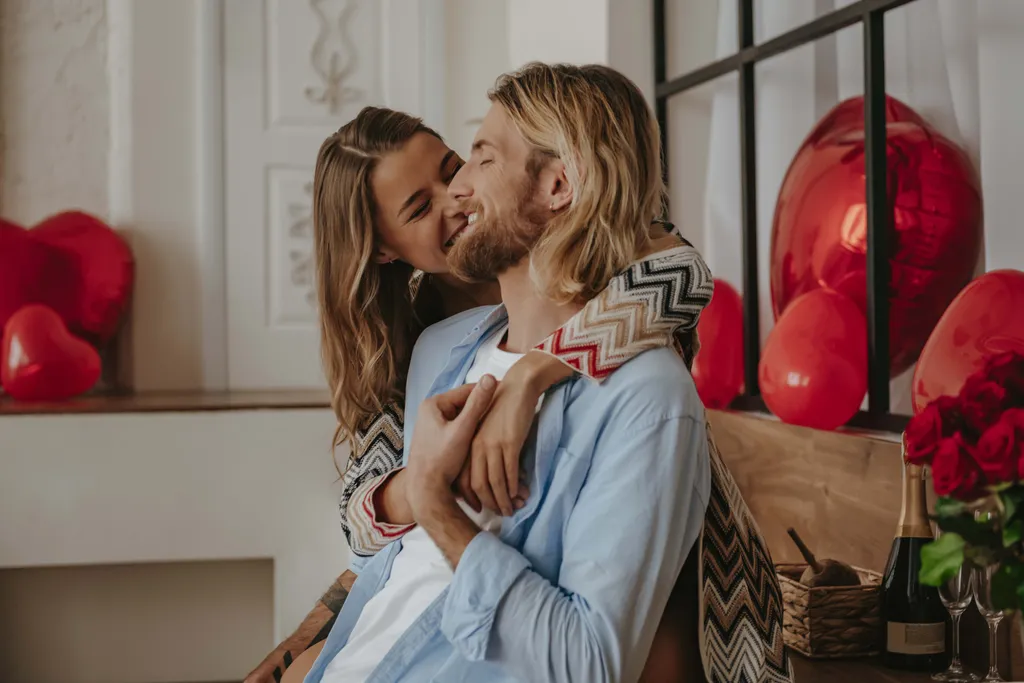 Romantisches Paar am Valentinstag mit Herzballons, sie umarmen sich