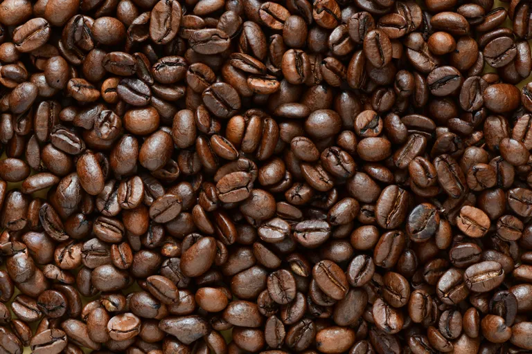 Detailaufnahme von dunkel gerösteten Kaffeebohnen mit sichtbarer Struktur und Oberfläche