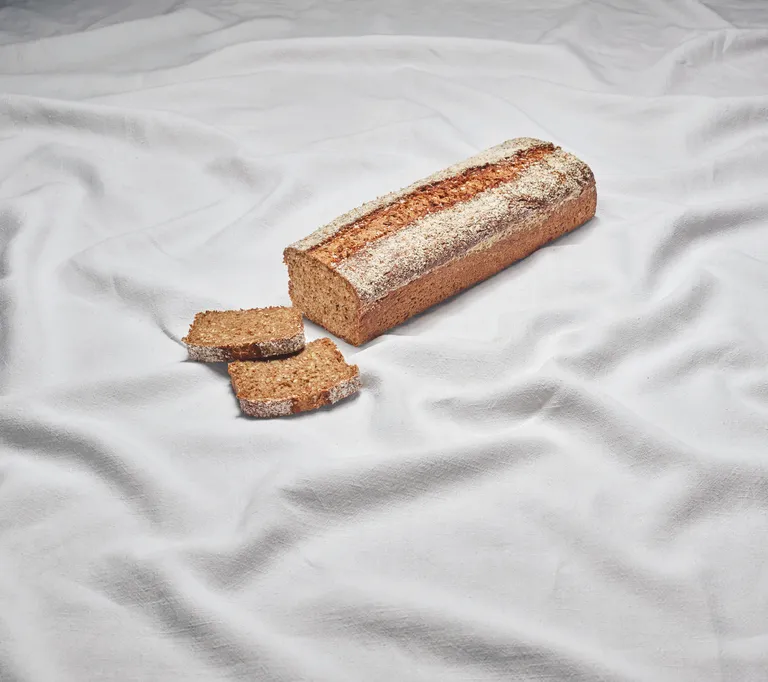 Ein Vollkorniger Dinkelkasten aus der INTERSPAR-Backstube liegt zum Teil aufgeschnitten auf einem weißen Tuch