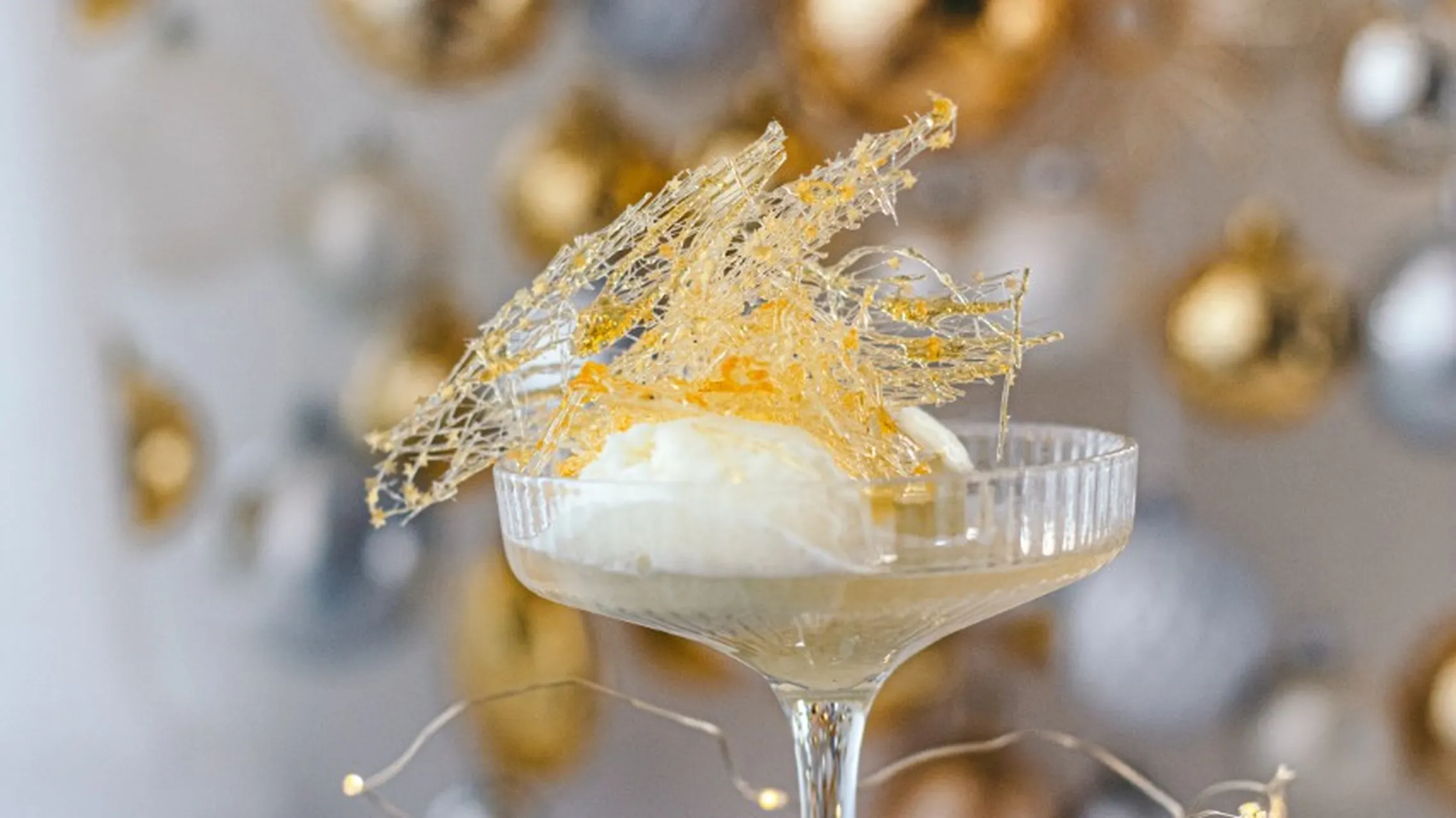Limetten-Champagner Cocktail vor festlichem Hintergrund