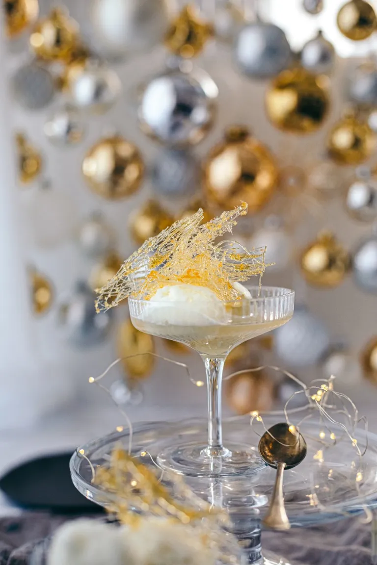 Limetten-Champagner Cocktail vor festlichem Hintergrund