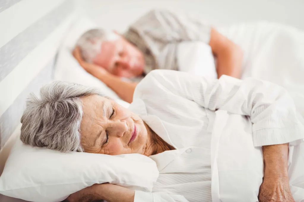 Älteres Paar schläft entspannt nebeneinander im Bett