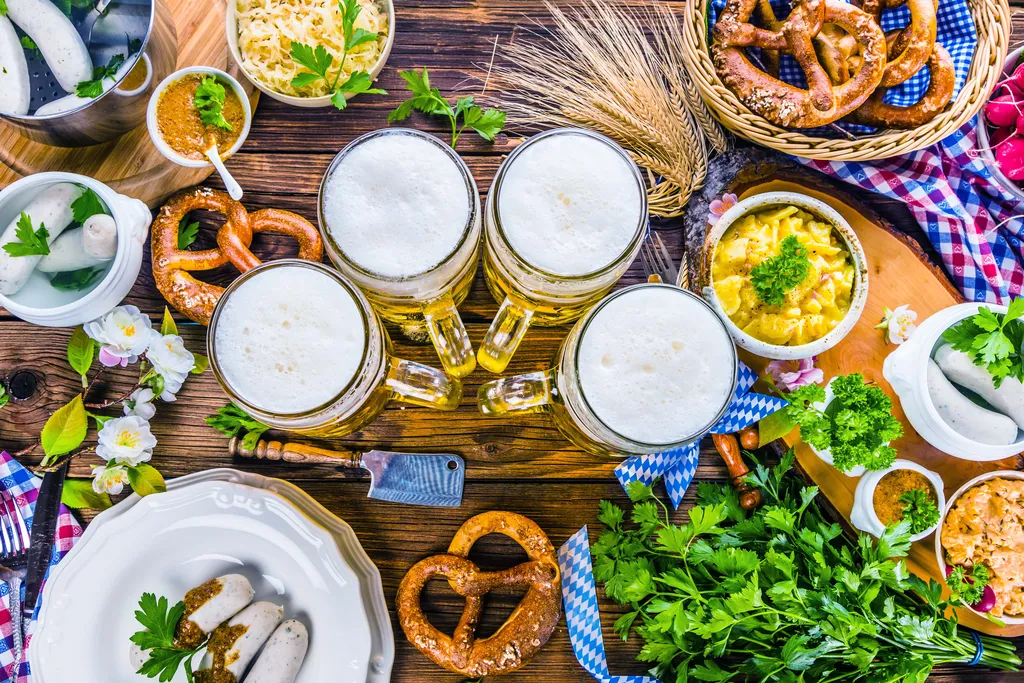 Ein Tisch gedeckt für das Oktoberfest mit Bier, Brezen und Würsten