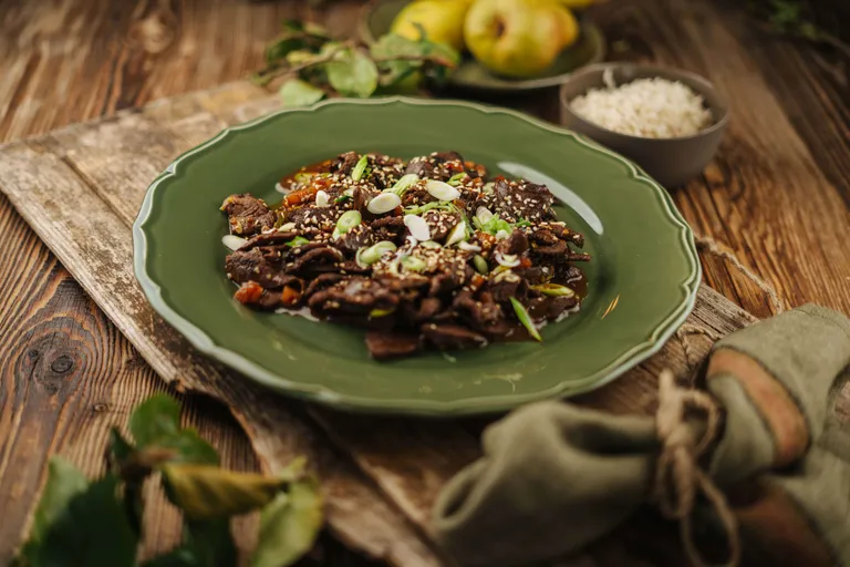 Asiatisch gewürztes Hirschragout mit Sesam und Frühlingszwiebeln