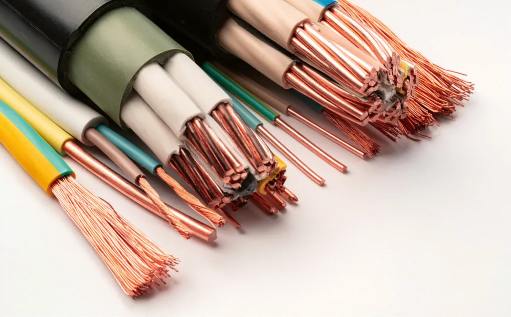 Close-up of various exposed copper wires with different insulation colors, showcasing twisted and stranded wire ends on a white surface.