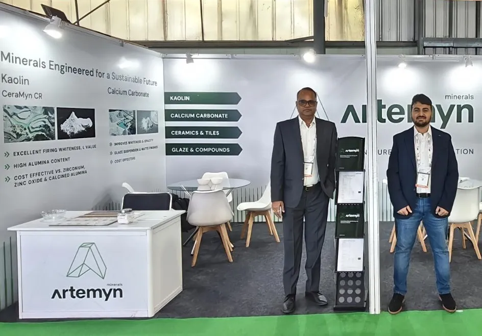 Two people stand in a trade show booth for Artemyn