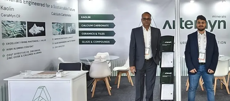 Two people stand in a trade show booth for Artemyn