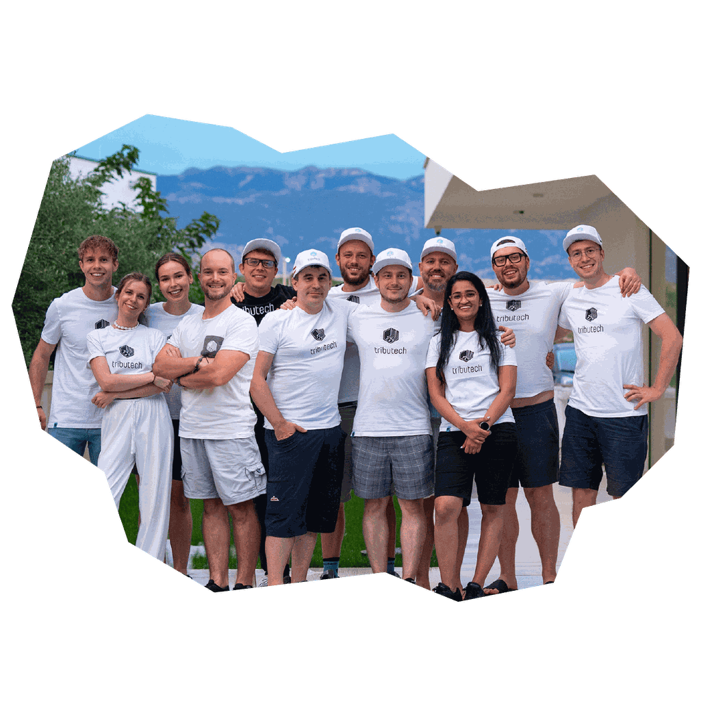 A group of people wearing matching white "tributech" shirts and caps, posing happily outdoors with trees and mountains in the background.