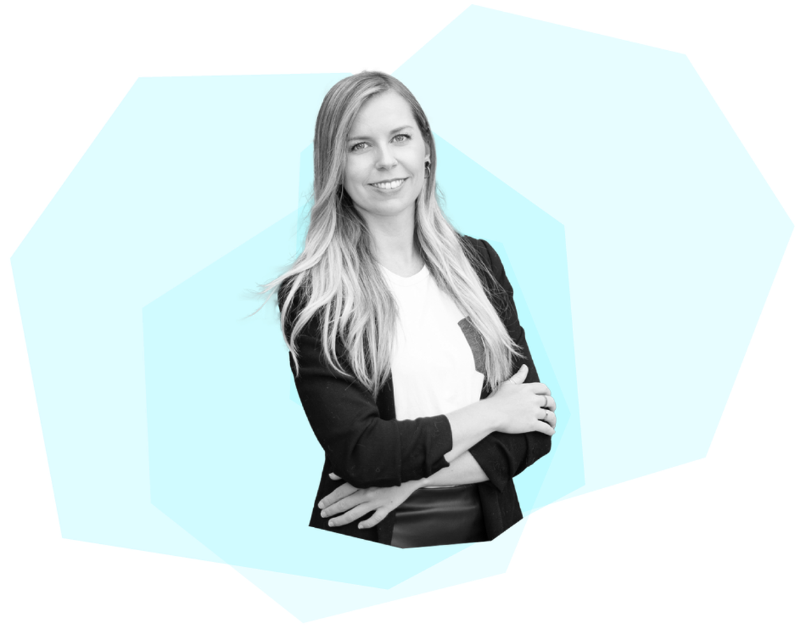 Smiling woman with long blonde hair in a black jacket, arms crossed, on a turquoise geometric background.