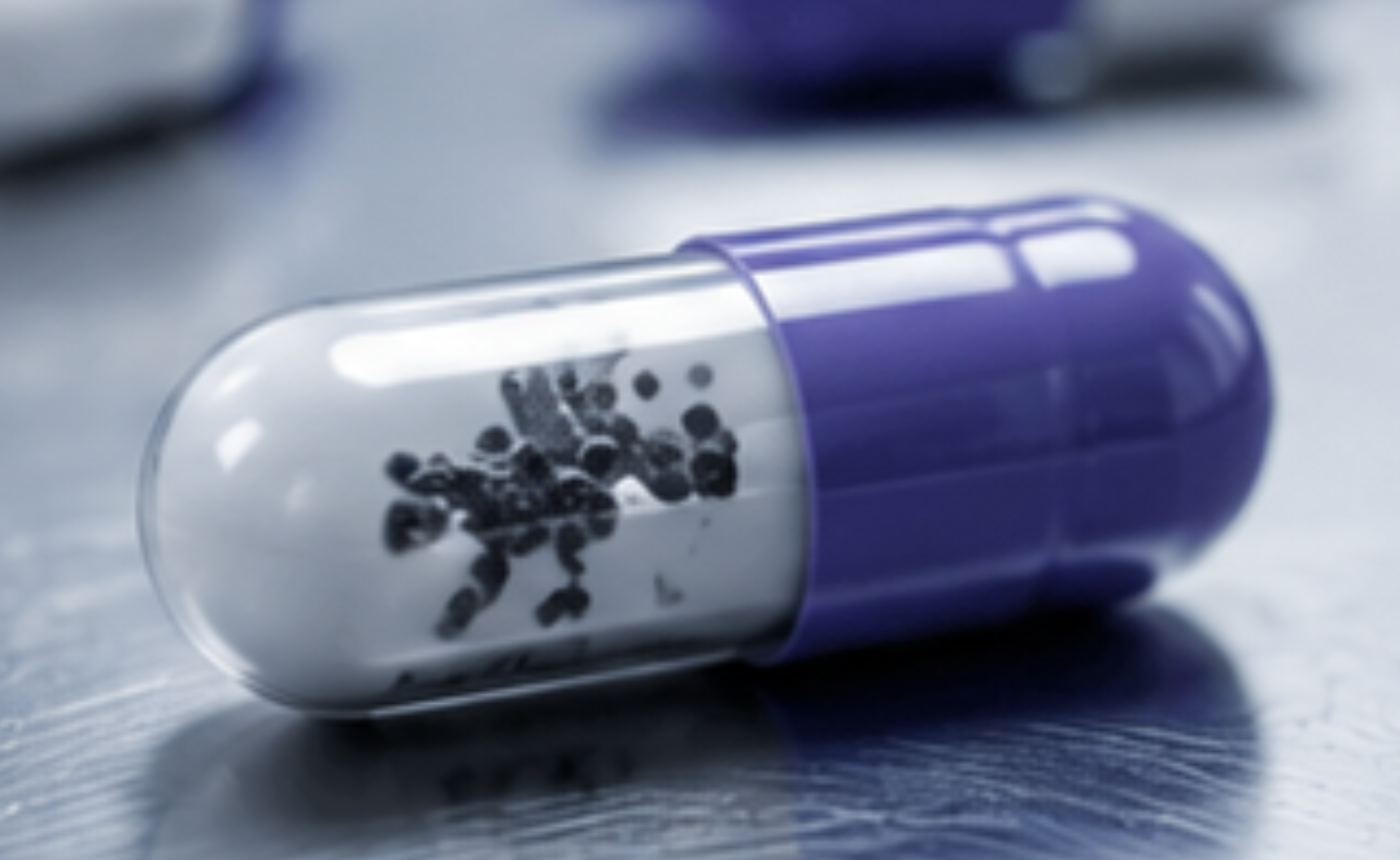 Cápsula farmacéutica con partículas contaminantes en su interior detectadas mediante un sistema de visión artificial.