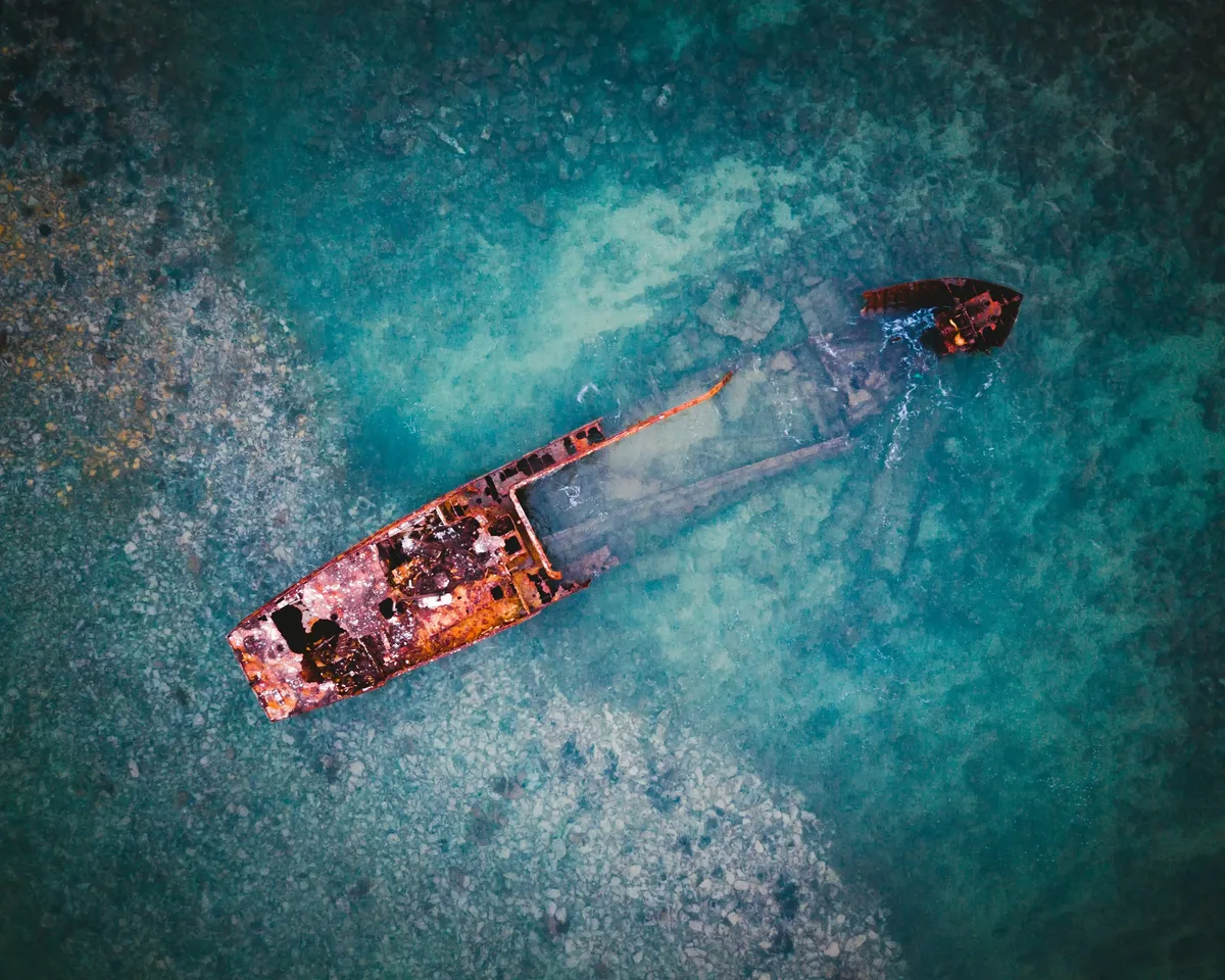 Vista aérea de un barco abandonado sobre aguas turquesas en Santo Tomé y Príncipe