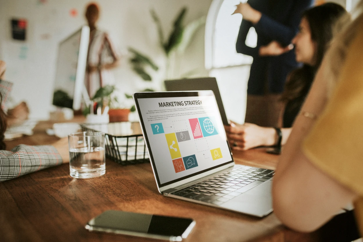 Laptop displaying a marketing strategy presentation during a team meeting