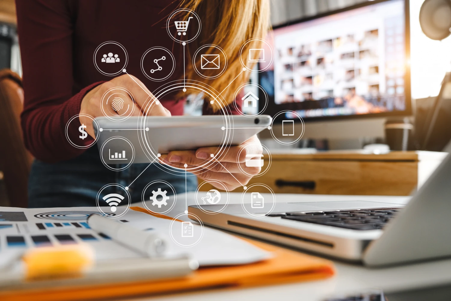 Icons representing e-commerce features — cart, payments, security, and analytics — overlaid on a person using a tablet at a desk