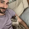 A man holding a tabby cat in his arms