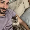 A man holding a tabby cat in his arms