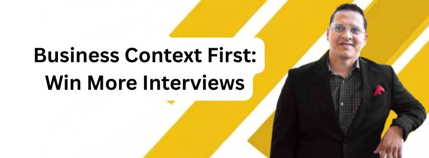 Man in a black suit with red pocket square stands beside text: "Business Context First: Win More Interviews" on a yellow background.