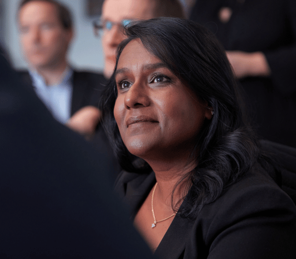 Frau sitzt in Meeting mit anderen Personen