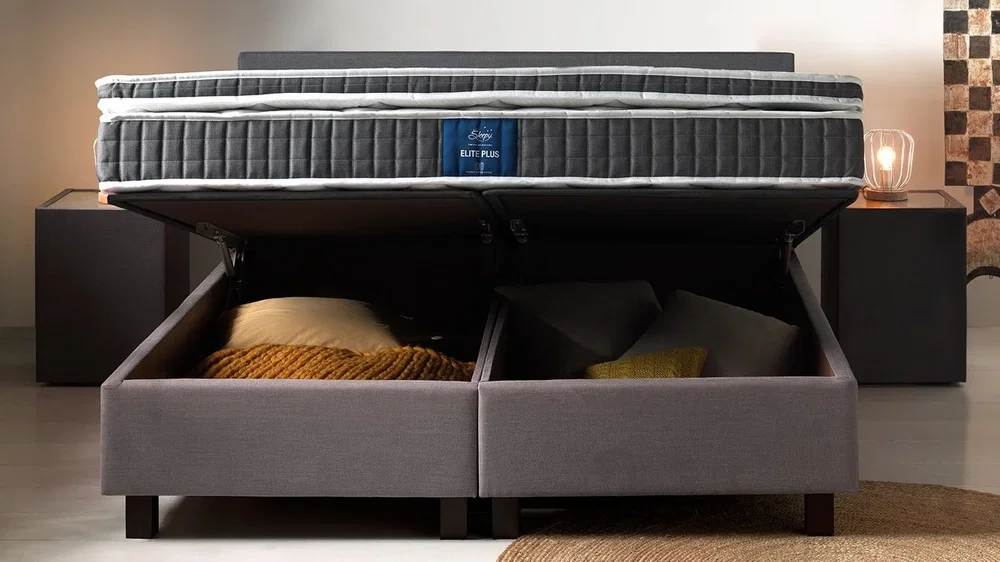 Geopende Sleepy Scandinavian Storage hotelbox met opbergruimte onder het ligoppervlak