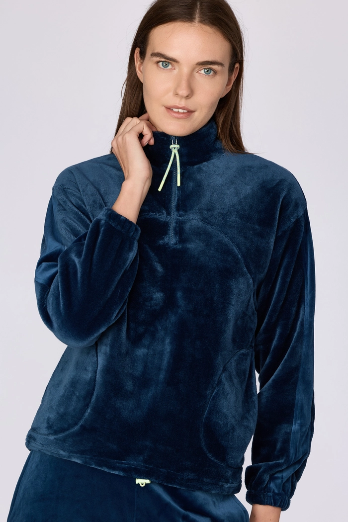 Model in een blauw Woody velours huispak voor dames