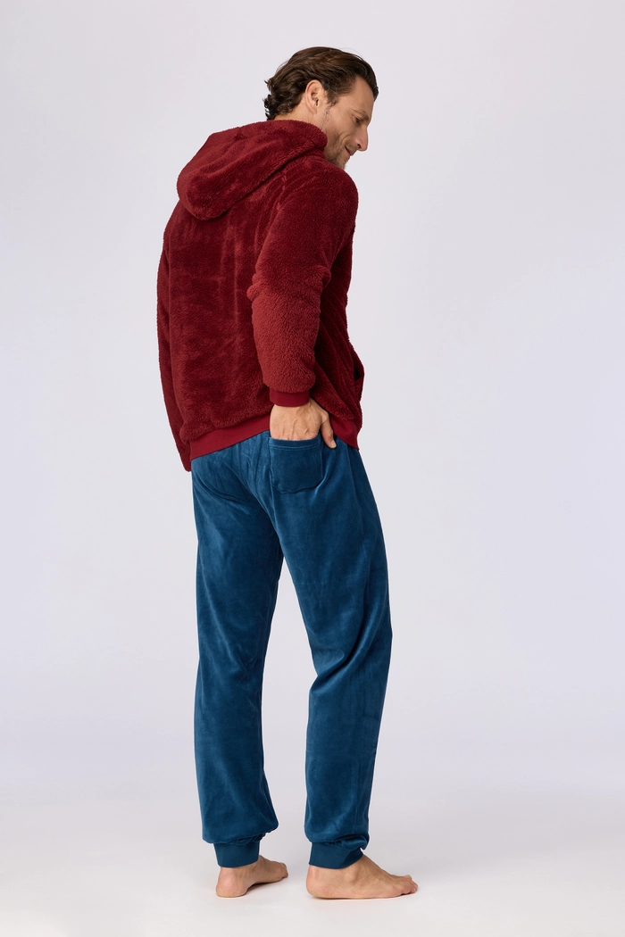 Model draagt het Woody Teddy huispak voor heren tijdens een ontspannen thuismoment