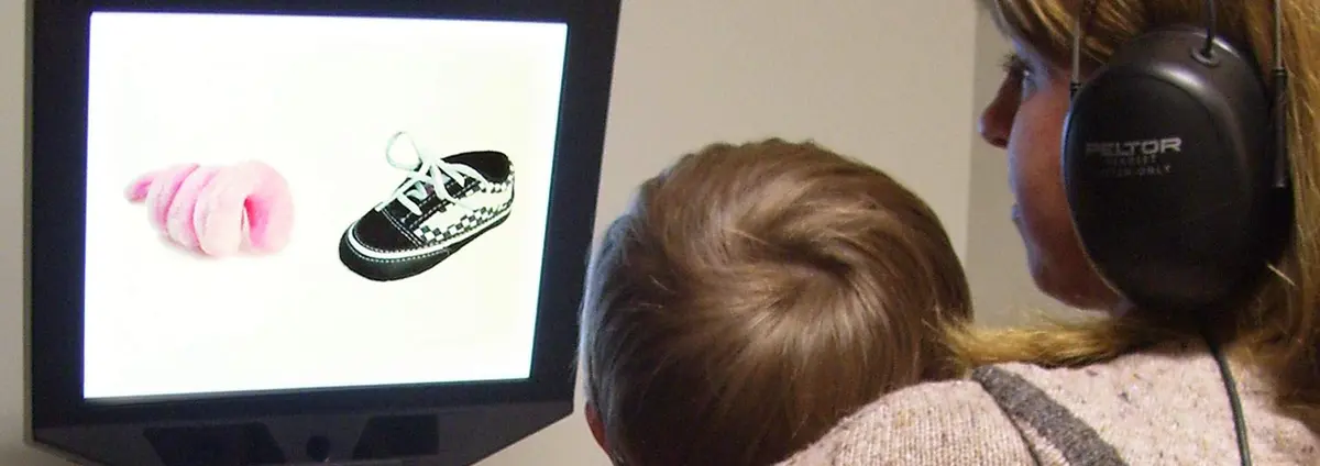  A toddler sitting on his mom’s lap watches the  disfluency study movie on the Tobii Pro screen based eye tracker.