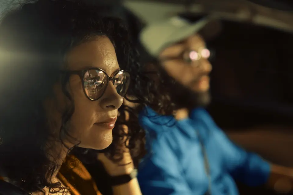 A man driving and a woman in the passenger seat in a car
