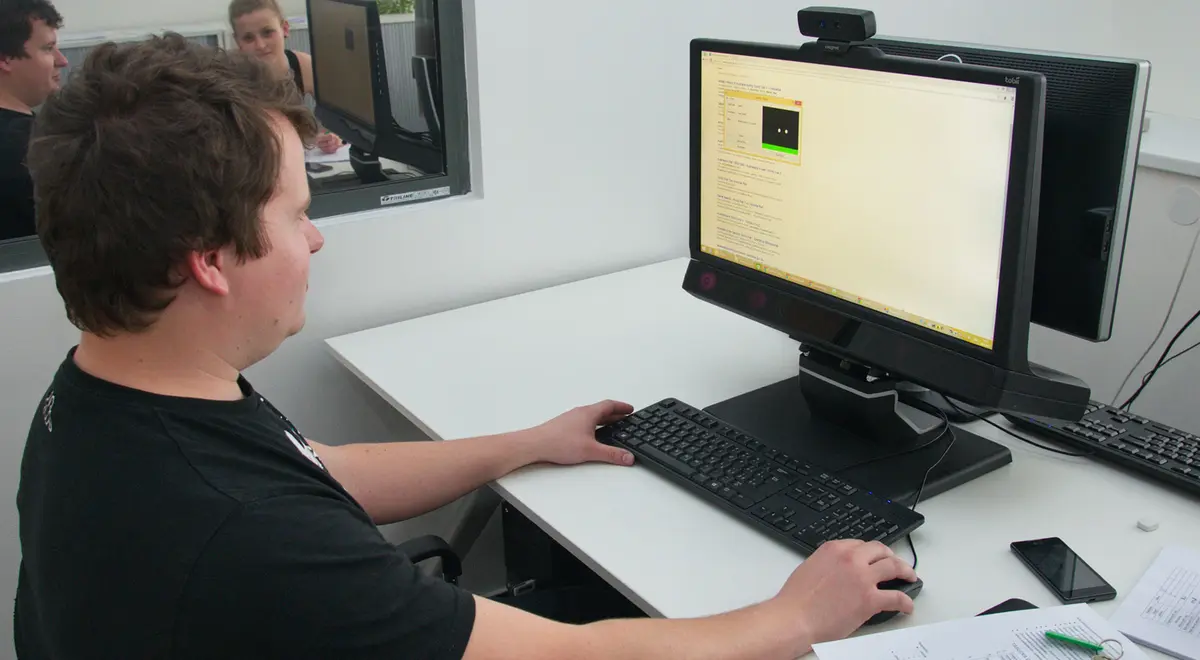 A person sitting in front of the Tobii Pro TX300 eye tracker in the UX lab.
