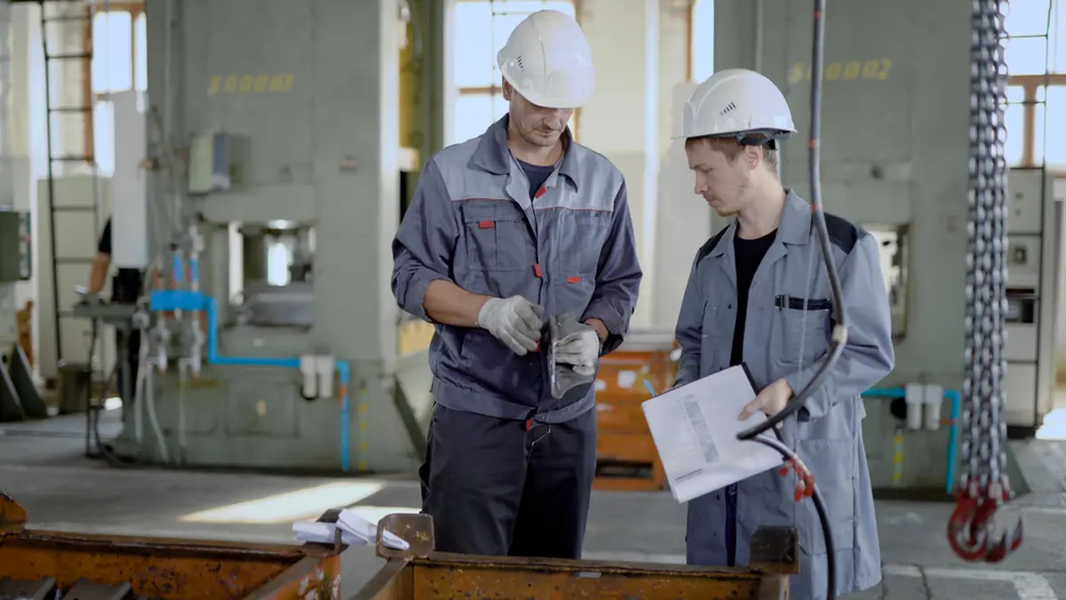 Two men are talking in front of the machine