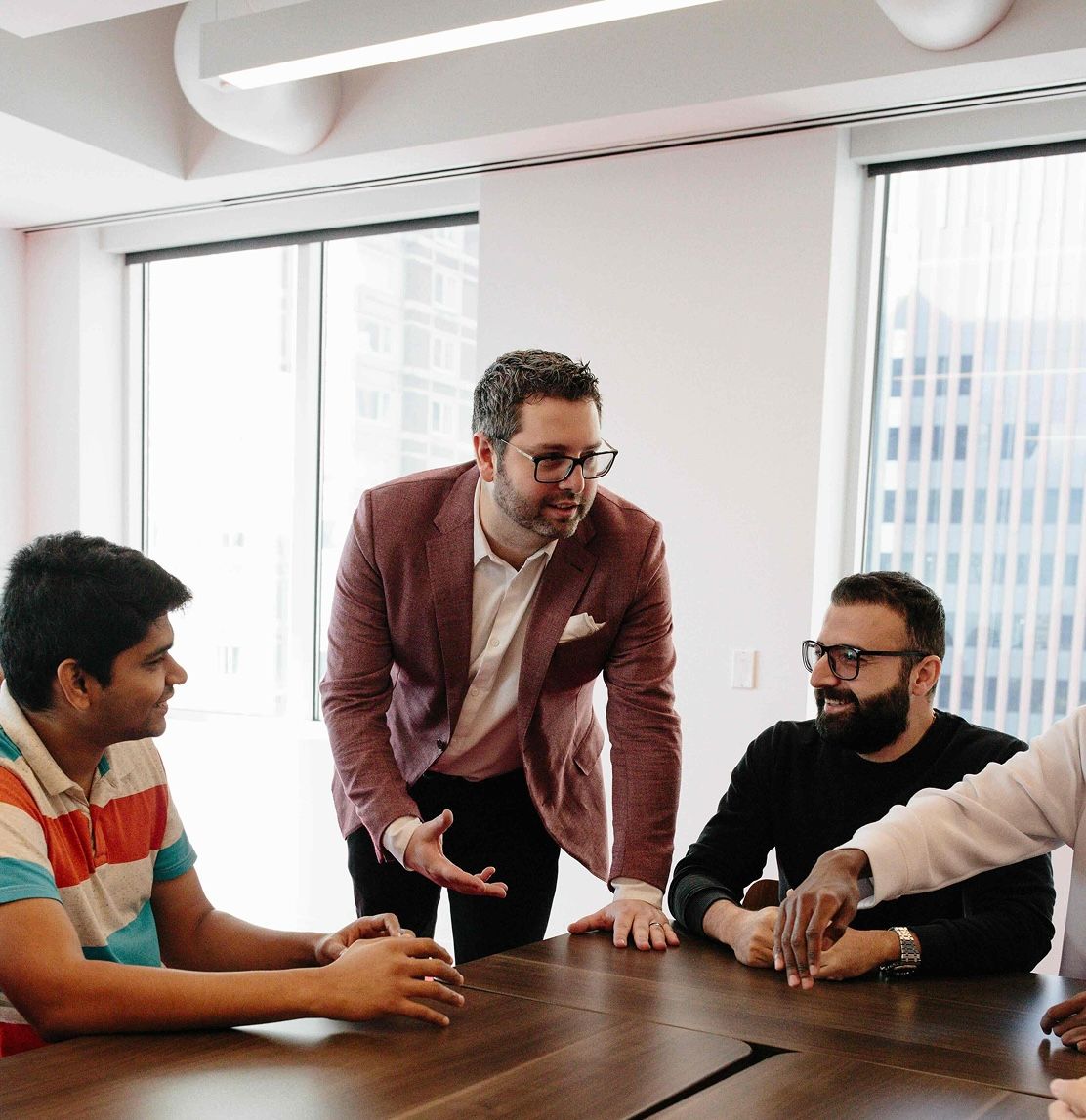 A group of colleagues engaged in a discussion around a conference table.