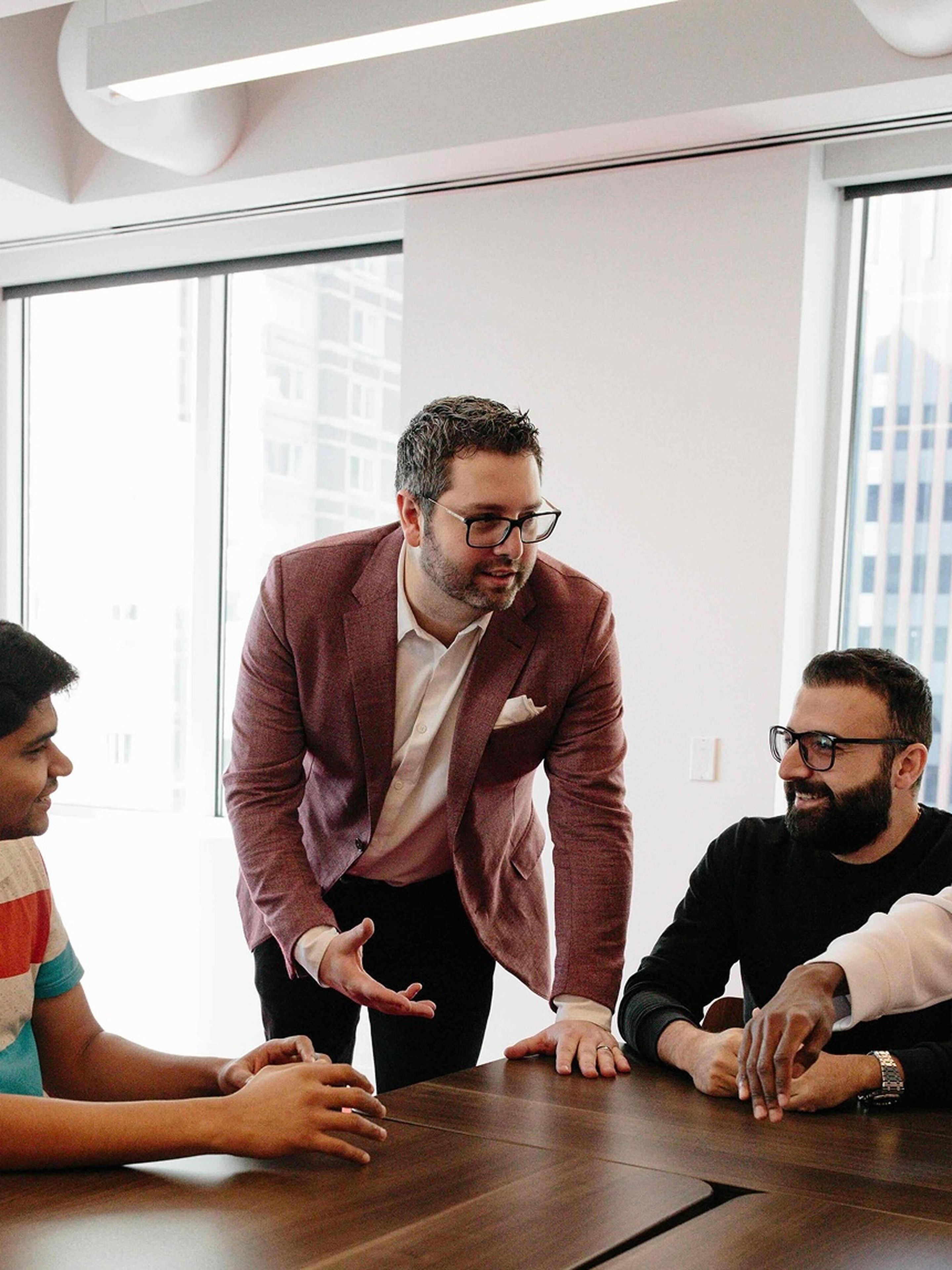 A group of colleagues engaged in a discussion around a conference table.