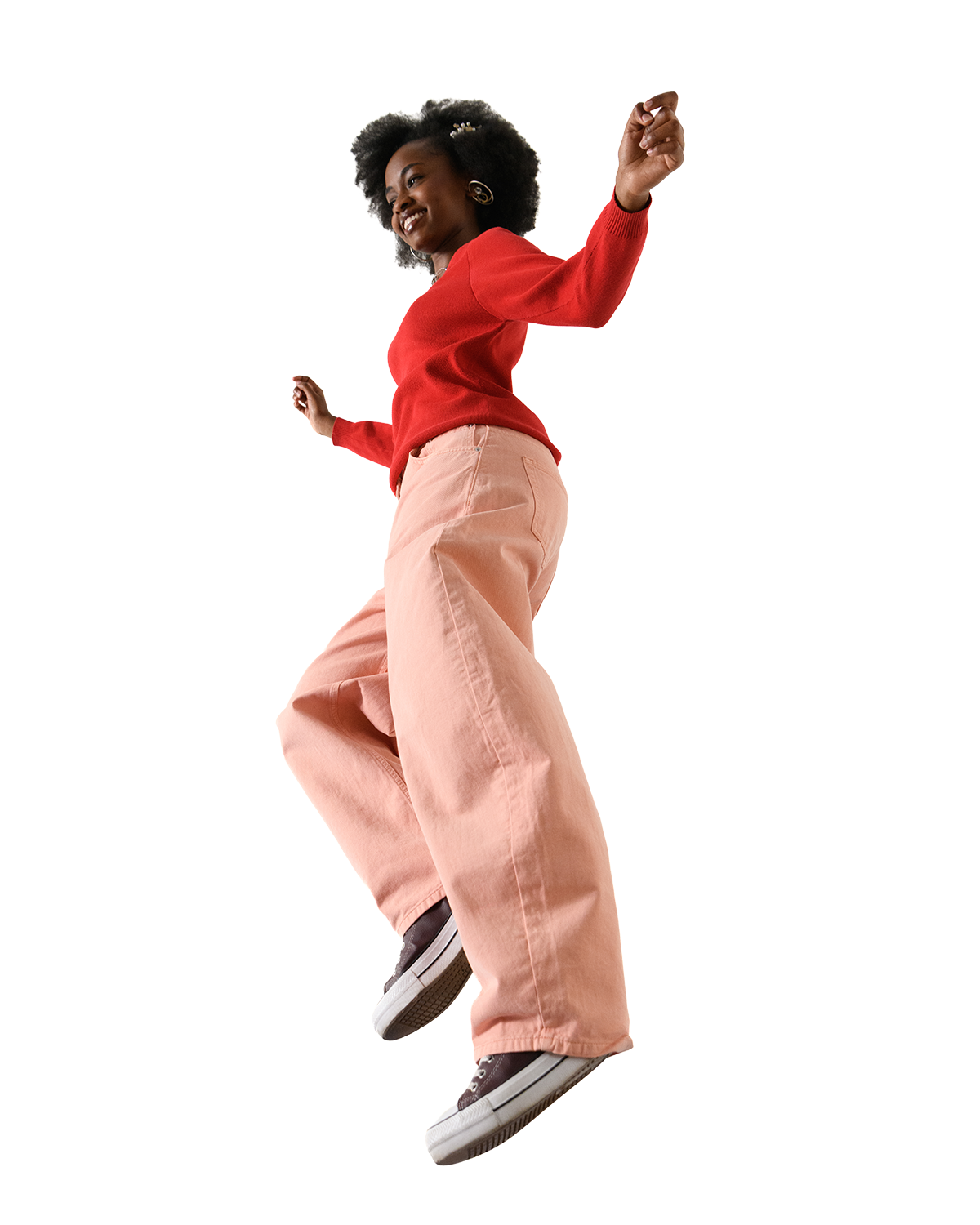 A person in bright clothing jumps energetically, smiling.