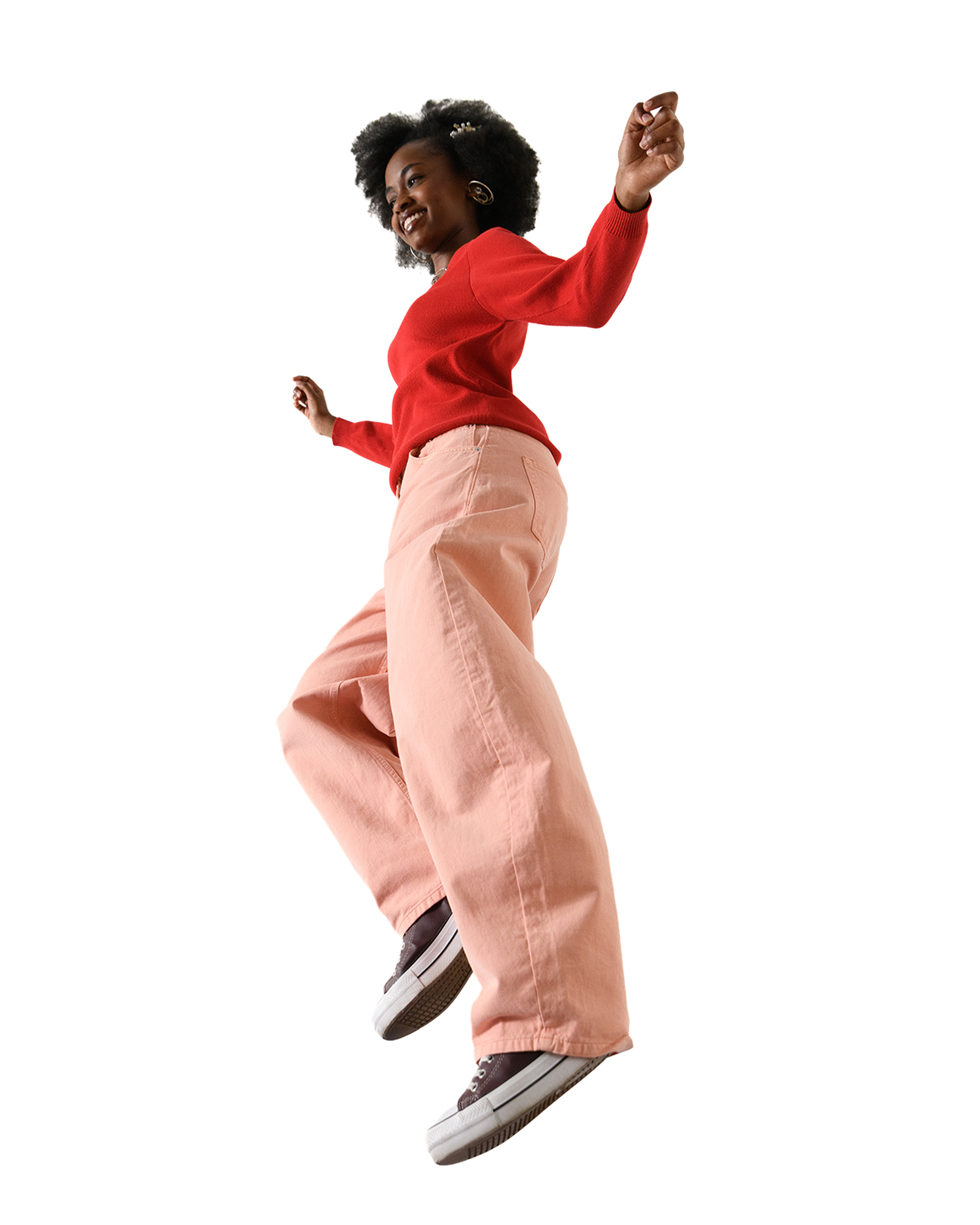 A person in bright clothing jumps energetically, smiling.